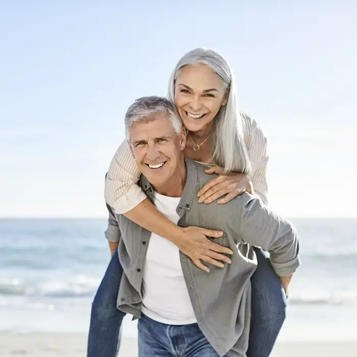 senior couple on a beach smiling
