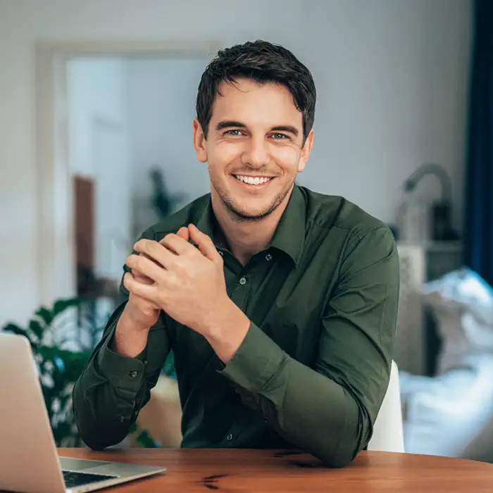 young adult man working from home and smiling